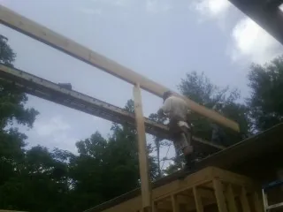 Carpenter setting a ridge beam over a new addition frame — Ice Dam Removal by Roofing Brothers in Reisterstown