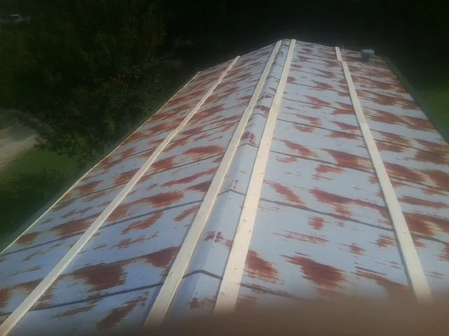 Rusted metal roof panels with new wood purlins before replacement — Storm Damage Roof Repair in Reisterstown by Roofing Brothers