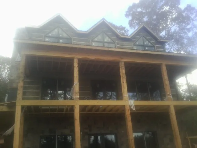 Dormers and porch framing on a large log home under construction — Roof Coating work by our crew in Reisterstown